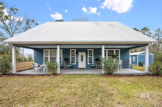 rear view of property with metal roof and a yard