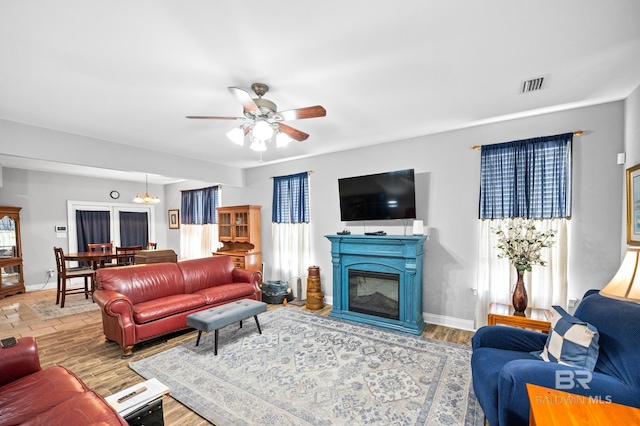 living room with baseboards, visible vents, and wood finished floors