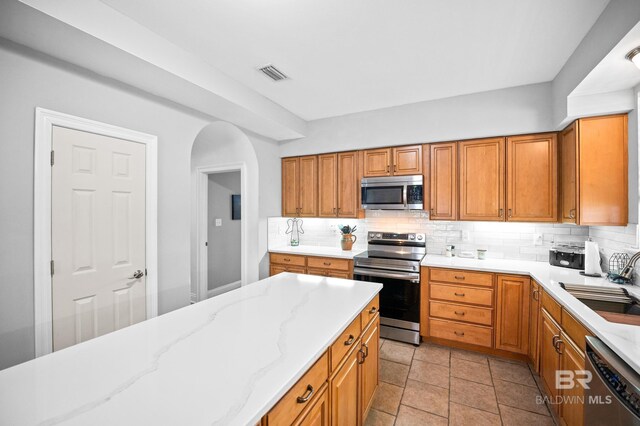 kitchen featuring tasteful backsplash, visible vents, stainless steel appliances, and a sink