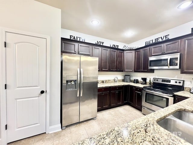 14775 Sonoma Blvd, Silverhill, AL 36576 - kitchen with dark brown cabinets, light stone counters, light tile patterned floors, recessed lighting, and appliances with stainless steel finishes