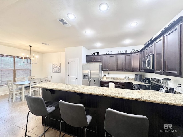 14775 Sonoma Blvd, Silverhill, AL 36576 - kitchen with visible vents, a notable chandelier, stainless steel appliances, a peninsula, and light stone countertops
