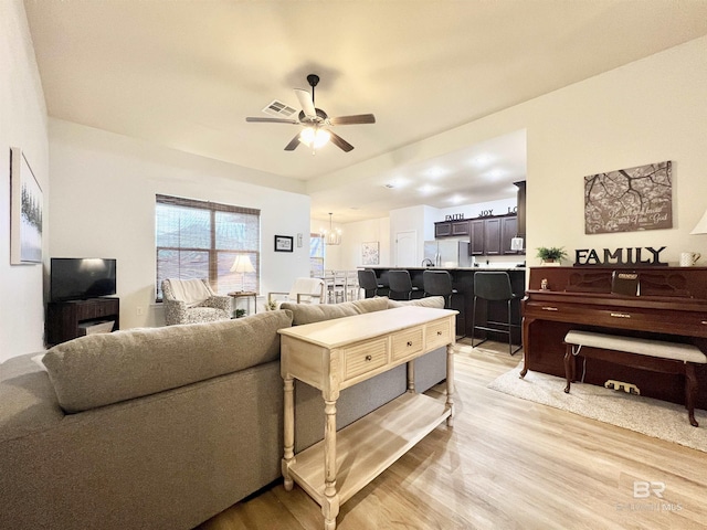 14775 Sonoma Blvd, Silverhill, AL 36576 - living room featuring visible vents, light wood finished floors, and ceiling fan with notable chandelier