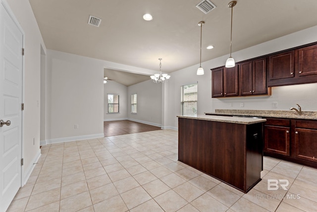 1464 Surrey Loop, Foley, AL 36535 - kitchen featuring a chandelier, light tile patterned flooring, a center island, decorative light fixtures, and light stone counters
