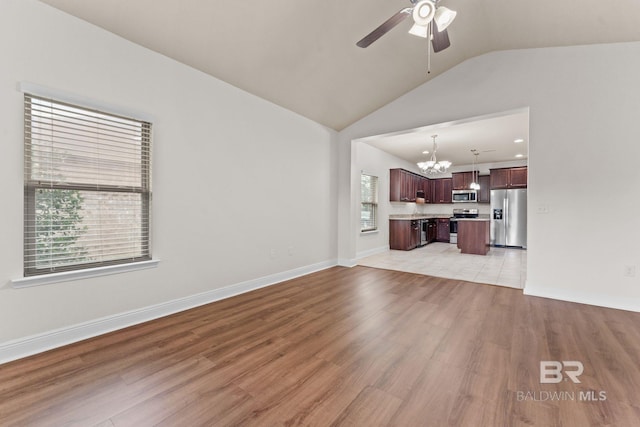 1464 Surrey Loop, Foley, AL 36535 - unfurnished living room featuring a chandelier, lofted ceiling, ceiling fan, and light wood-style floors