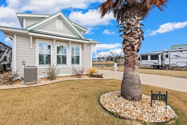 view of property exterior with a yard and central AC unit