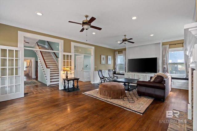 living room featuring ceiling fan, a healthy amount of sunlight, crown molding, and dark hardwood / wood-style flooring