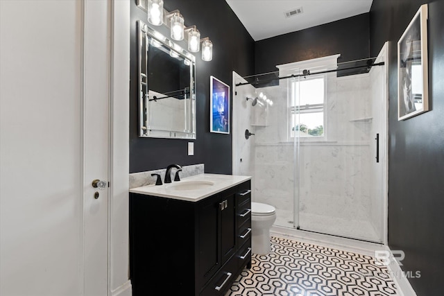 bathroom with vanity, toilet, a shower with door, and tile patterned flooring