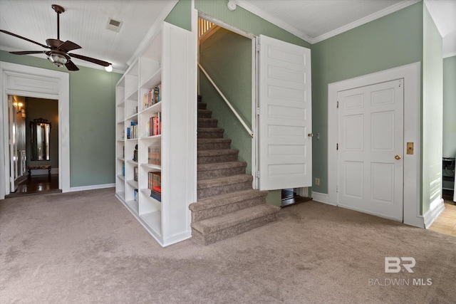 stairs with ceiling fan, carpet flooring, crown molding, and vaulted ceiling