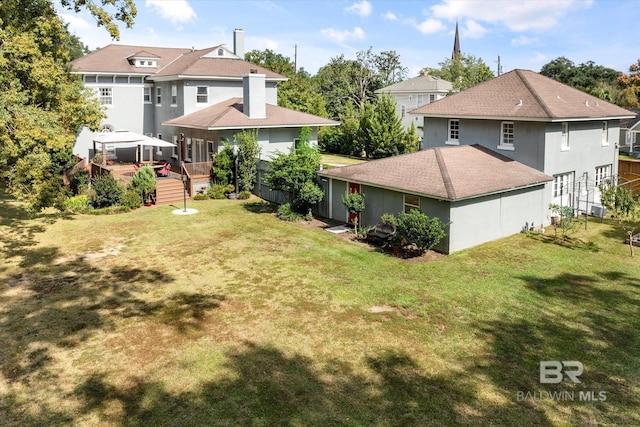 back of house with a gazebo, a lawn, and a wooden deck