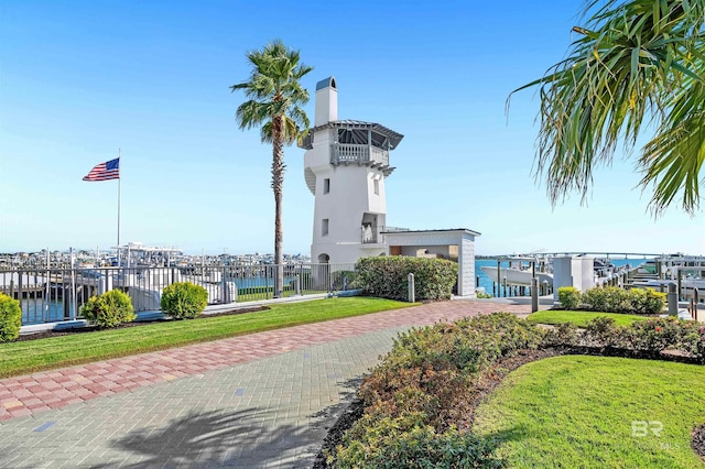 surrounding community featuring a lawn and a water view