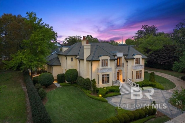 french country style house with a yard