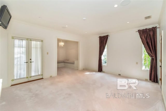 unfurnished room with ornamental molding, light carpet, and french doors