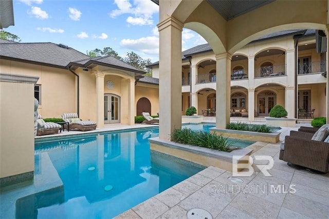 view of pool with french doors and a patio