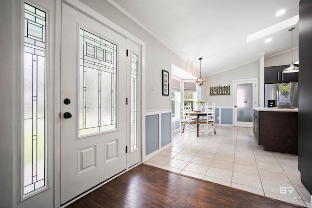 521 Parkwood Ave, Daphne, AL 36526 - foyer entrance with ornamental molding, lofted ceiling, a chandelier, light wood-type flooring, and a skylight