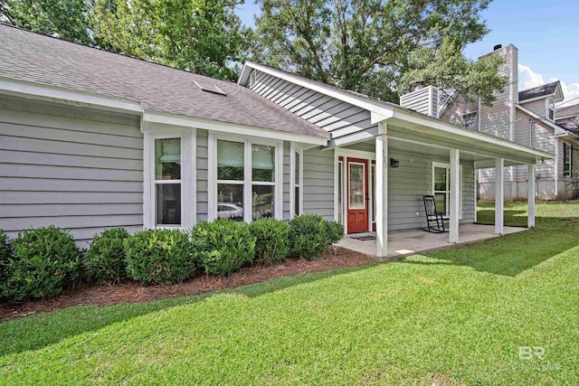521 Parkwood Ave, Daphne, AL 36526 - view of front of house with a front lawn, a chimney, a shingled roof, and a patio