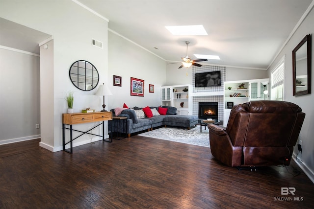 521 Parkwood Ave, Daphne, AL 36526 - living area featuring a tiled fireplace, vaulted ceiling, a skylight, wood finished floors, and a ceiling fan