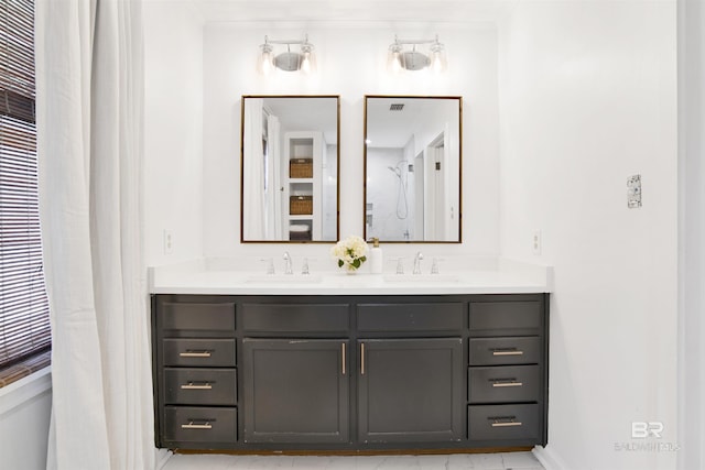 full bathroom featuring crown molding, double vanity, a sink, and baseboards
