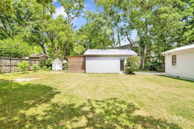 view of yard with a storage unit, fence, and an outdoor structure