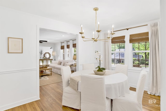 dining room featuring a chandelier, light wood-style floors, and crown molding