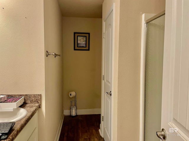 bathroom featuring hardwood / wood-style flooring, vanity, and a shower with door