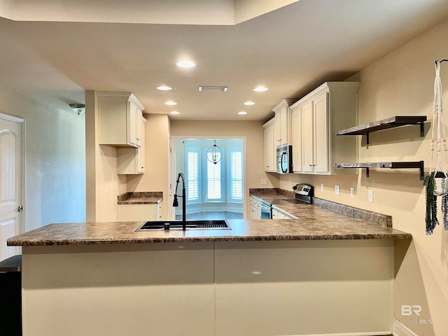 kitchen with white cabinets, sink, kitchen peninsula, and appliances with stainless steel finishes