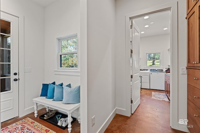 corridor with washing machine and clothes dryer, recessed lighting, finished concrete flooring, and baseboards