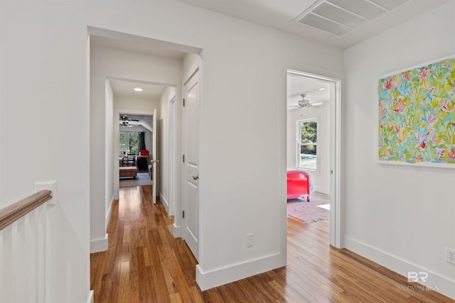 corridor with visible vents, baseboards, and wood-type flooring