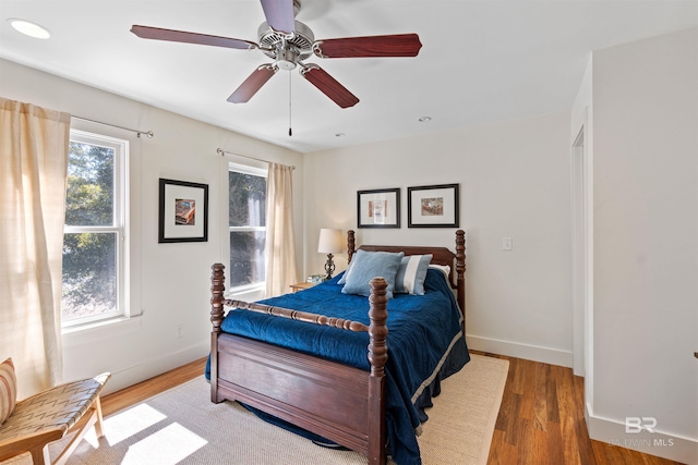 bedroom with ceiling fan, baseboards, and wood finished floors