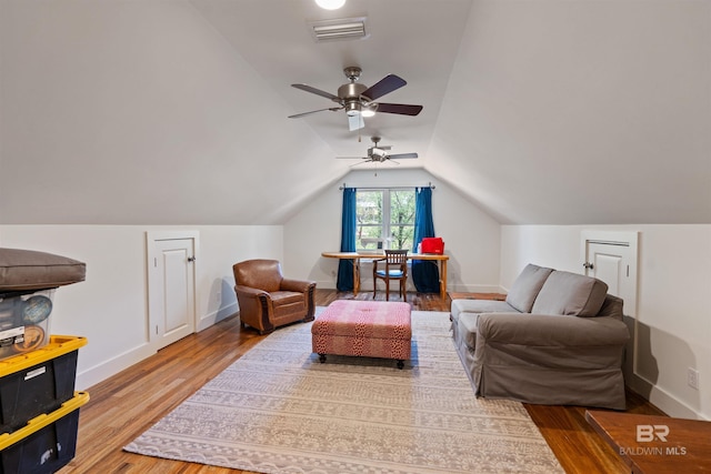 living room with wood finished floors, visible vents, baseboards, ceiling fan, and vaulted ceiling