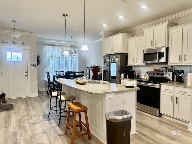 kitchen featuring white cabinets, appliances with stainless steel finishes, ornamental molding, and visible vents