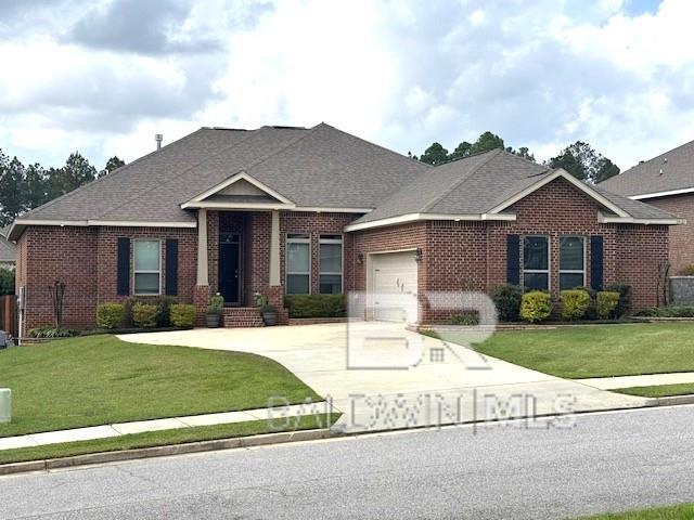 view of front of house with fence, driveway, an attached garage, a front lawn, and brick siding