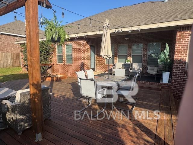 deck featuring outdoor dining area and fence