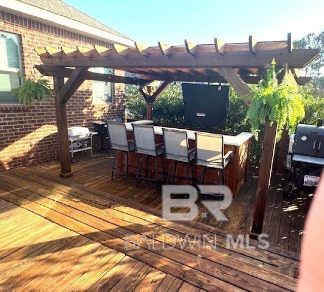 wooden deck featuring a pergola and outdoor dry bar