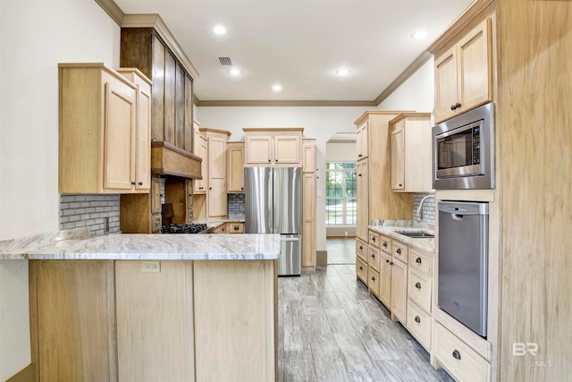 kitchen featuring stainless steel appliances, decorative backsplash, light wood-type flooring, light brown cabinets, and ornamental molding