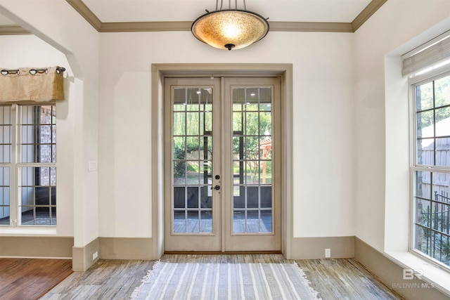 doorway with light wood-type flooring, french doors, and ornamental molding