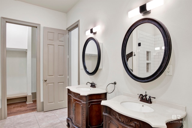 bathroom with dual bowl vanity and hardwood / wood-style floors