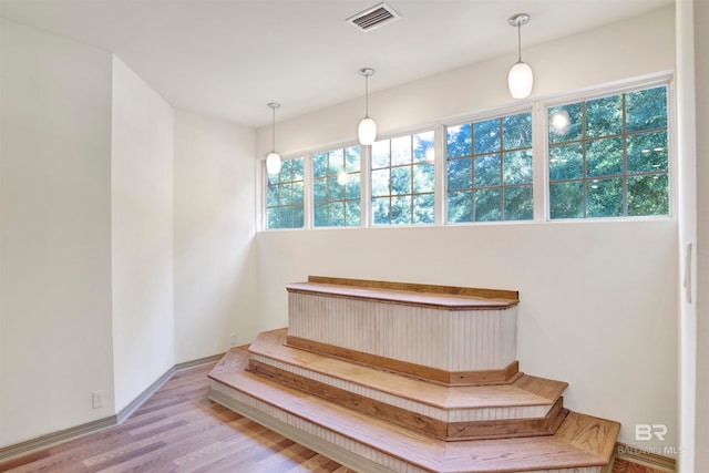 stairs with wood-type flooring and plenty of natural light