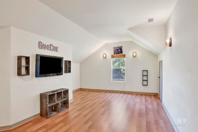 additional living space with lofted ceiling and hardwood / wood-style floors