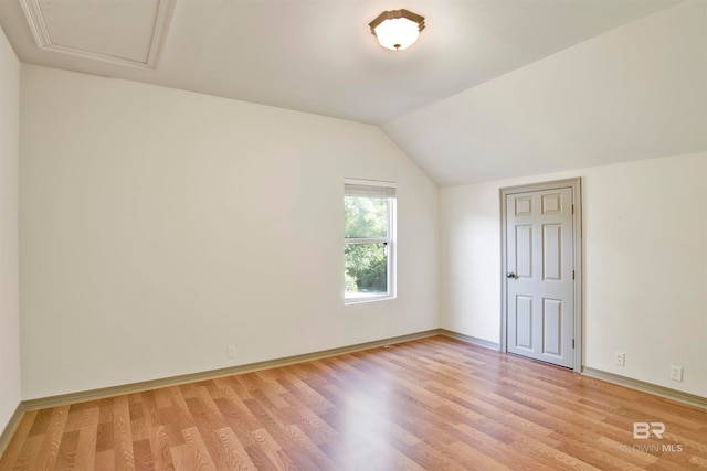 additional living space featuring vaulted ceiling and light wood-type flooring