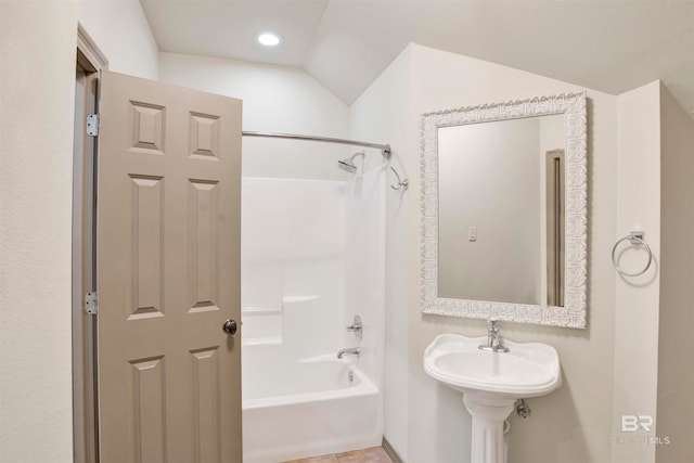 bathroom featuring tile patterned floors, washtub / shower combination, and vaulted ceiling