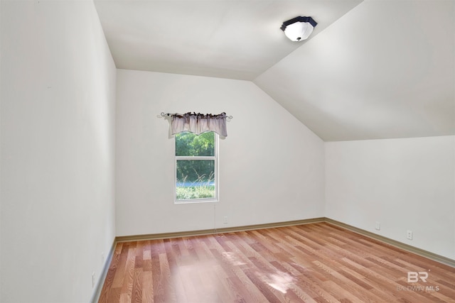 additional living space featuring lofted ceiling and hardwood / wood-style floors