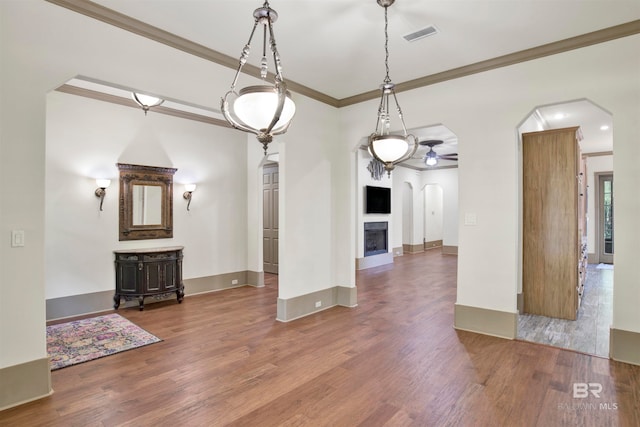 unfurnished dining area with crown molding, hardwood / wood-style floors, and ceiling fan