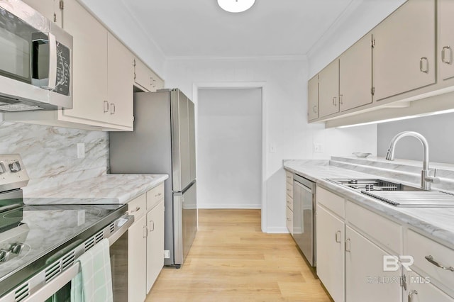 18 Rollins Pl, Atmore, AL 36502 - kitchen featuring appliances with stainless steel finishes, light countertops, ornamental molding, light wood-type flooring, and backsplash