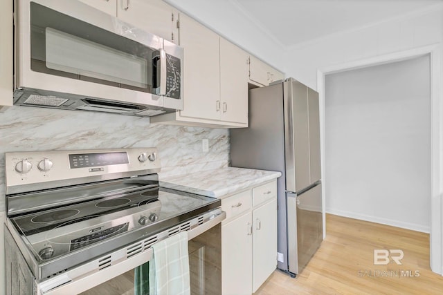 18 Rollins Pl, Atmore, AL 36502 - kitchen featuring appliances with stainless steel finishes, light countertops, crown molding, light wood-style floors, and decorative backsplash