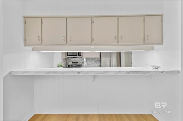 18 Rollins Pl, Atmore, AL 36502 - kitchen featuring stainless steel appliances, light wood-type flooring, light countertops, and a peninsula