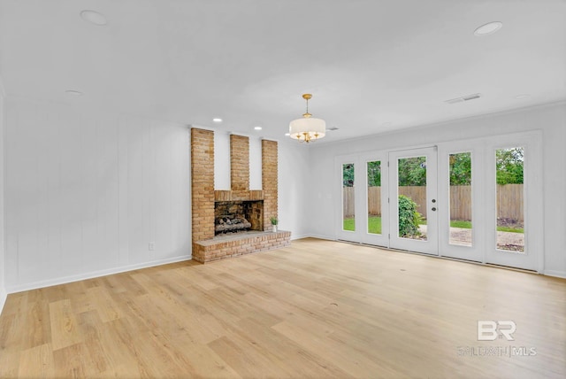 18 Rollins Pl, Atmore, AL 36502 - unfurnished living room featuring light wood-type flooring, a chandelier, recessed lighting, and a brick fireplace