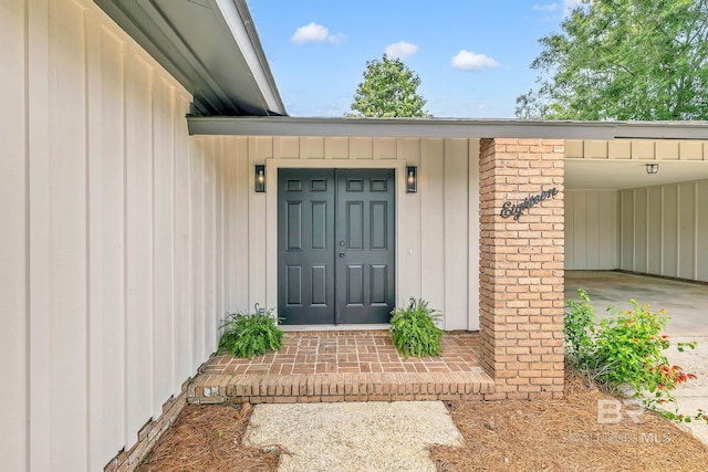 18 Rollins Pl, Atmore, AL 36502 - doorway to property featuring board and batten siding and a carport