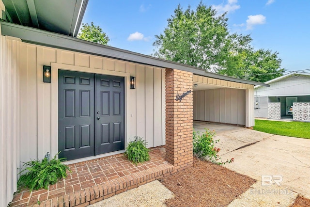 18 Rollins Pl, Atmore, AL 36502 - view of exterior entry with driveway, board and batten siding, and brick siding