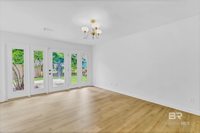 18 Rollins Pl, Atmore, AL 36502 - spare room featuring a chandelier, healthy amount of natural light, and wood finished floors