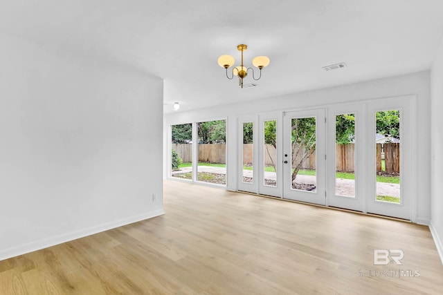 18 Rollins Pl, Atmore, AL 36502 - unfurnished living room with a chandelier, wood finished floors, and french doors